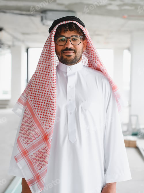 Preview: Arab businessman wearing traditional clothing inspecting construction site of new business center