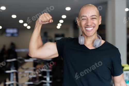 Preview: Hispanic bald man athlete in gym flexing his bicep muscle