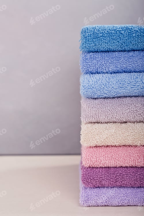 Preview: Stack of colorful bath towels on light background.