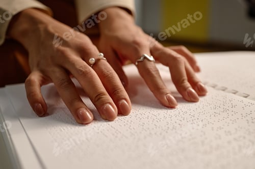Preview: Closeup of Young Adult Woman Reading Braille Pages in Library Setting