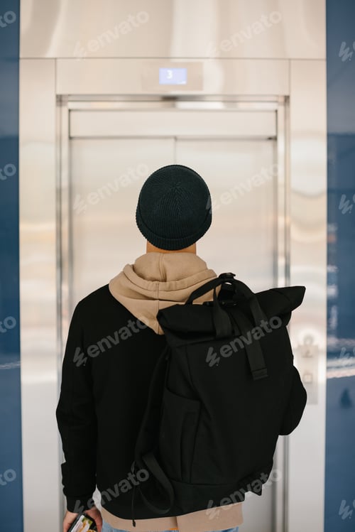 Preview: A young male IT worker is waiting for the elevator. The concept of work in the office.