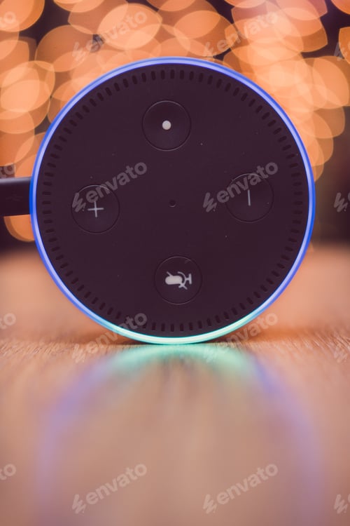 Preview: Amazon Alexa echo dot on wooden table with blurred lights in background