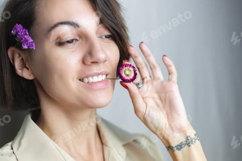 Preview: woman with no makeup natural beauty holding dried flower gray white background.