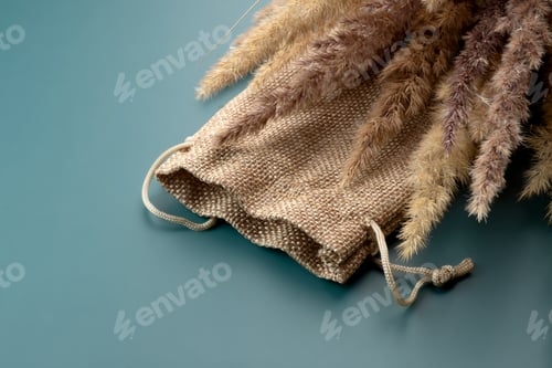 Preview: empty eco canvas bag blank and dry reeds and bunch of dry reeds on green background. decoration