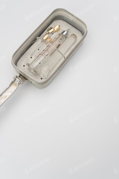 Preview: isolated sterilized glass injection syringe in a box on a white paper background