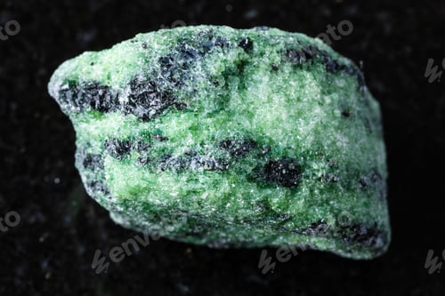 Vista previa: sample of raw zoisite rock on black granite