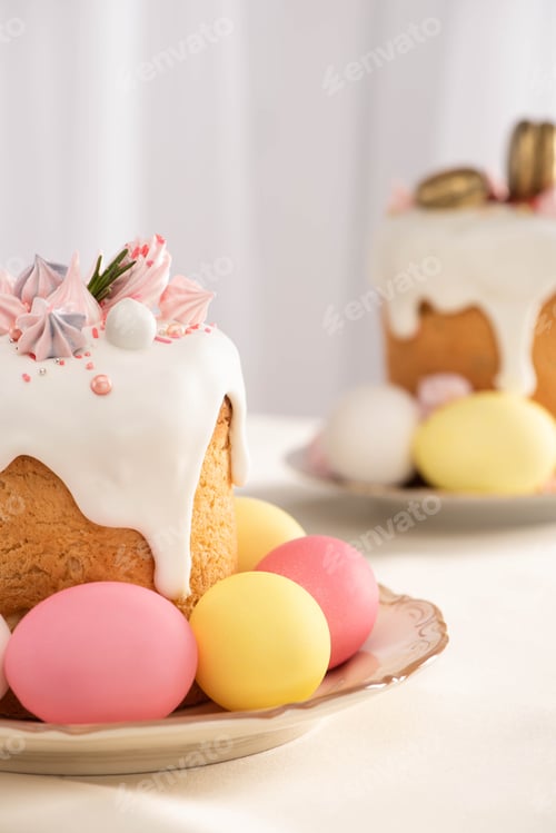 Preview: selective focus of delicious Easter cakes with meringue and colorful eggs on plates