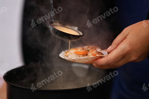 Preview: Woman pours sauce on a scallop
