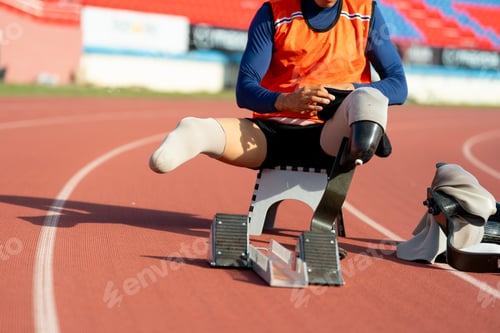 Preview: Asian para-athletes with prosthetic blades sprint on a running track at stadium.