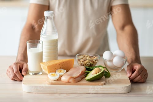 Preview: Cropped view of fit young guy standing near wholesome protein products at kitchen, closeup