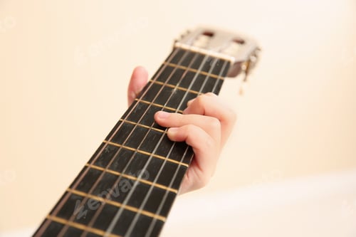 Preview: Little girl playing wooden guitar, closeup view