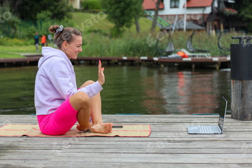 Preview: Woman with Laptop Waving Hand Sitting on Dock
