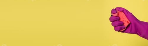 Preview: partial view of man in pink rubber glove holding sponge isolated on yellow, banner