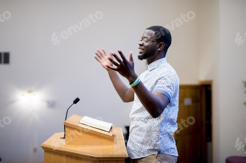Preview: Shallow fouse shot of a male talking near a wooden tribune with his hands up