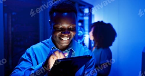 Preview: Man, tablet and server room at night for technology, maintenance in dark data center with neon. Mal