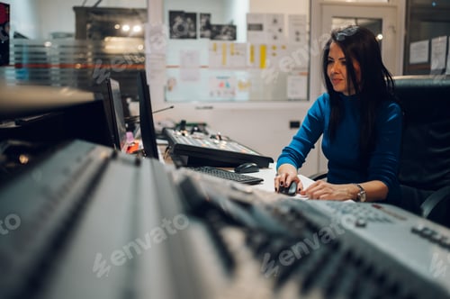 Preview: Middle aged woman using equipment in control room on a tv station