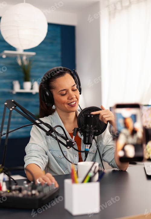 Preview: Vlogger on air during her podcast channel using mixer and professional microphone