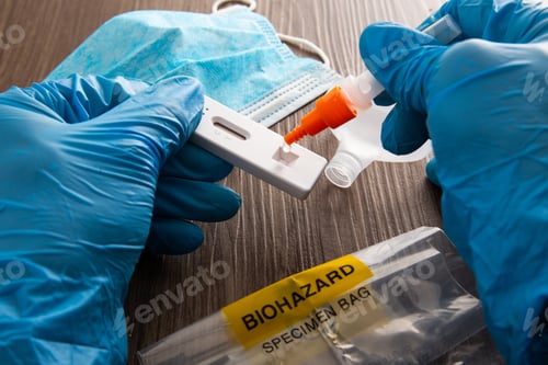 Preview: Hand with blue surgical glove placing the sample into the covid-19 antigen diagnostic test device