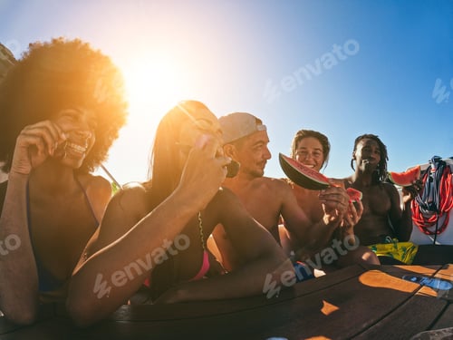 Preview: Happy multiracial friends eating watermelon while doing sea tour with sailing boat