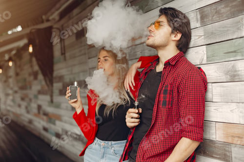 Preview: Stylish young couple with vape in a city