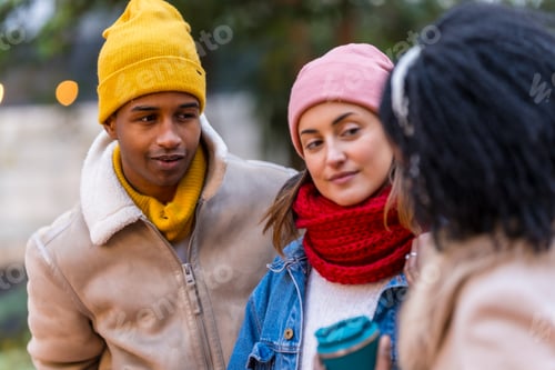 Preview: Three friends talking and walking in city during winter