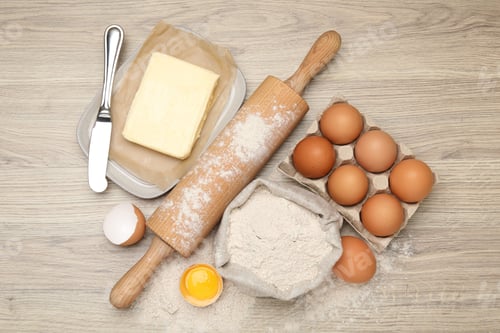 Preview: Rolling pin and different ingredients on light wooden table, flat lay