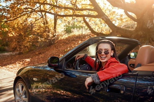 Preview: Woman in red in cabriolet. She wearing sunglasses