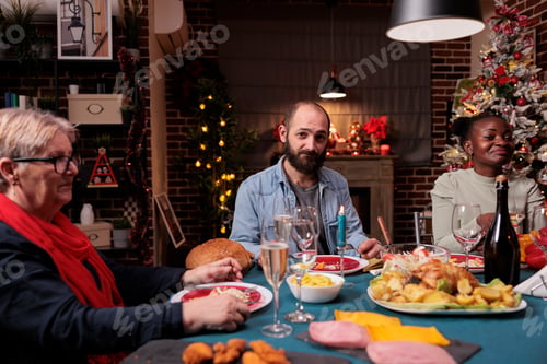 Preview: Family christmas celebration, friends drinking at festive dinner table