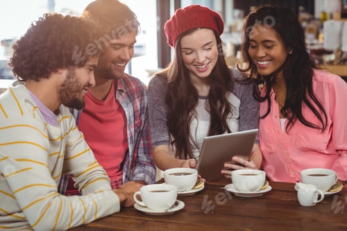 Preview: Group Of Friends Using Digital Tablet While Having Cup Of Coffee In Cafe