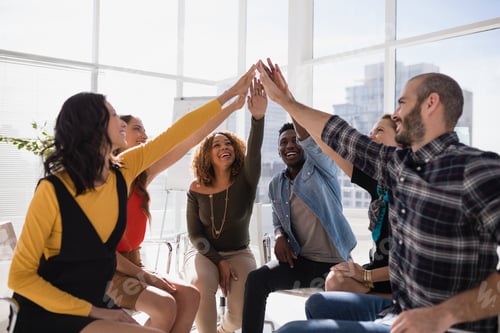 Preview: Group of happy executives giving high five to each other