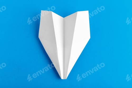Preview: Flat lay of a paper plane on pastel blue color background