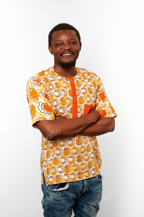 Preview: Smiling black man with crossed arms in African bright clothes isolated on white background