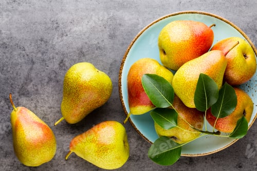 Preview: Fresh bio pear with leaves on the plate. Gray stone table.
