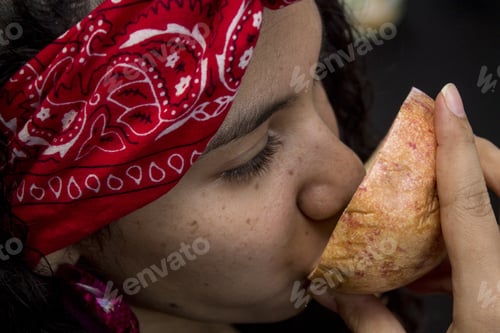 Preview: Latin American woman eating a slice of a tropical fruit
