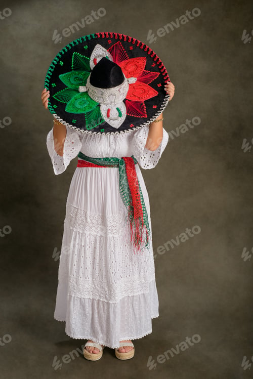 Preview: Woman shows Mexican hat with the colors of the Mexican flag. Typical clothing and mariachi hat.