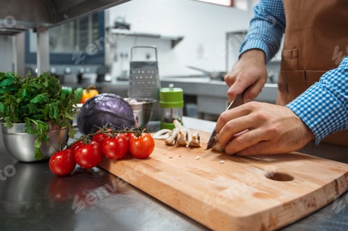 Preview: The chef in brown apron cooking in a restaurant kitchen