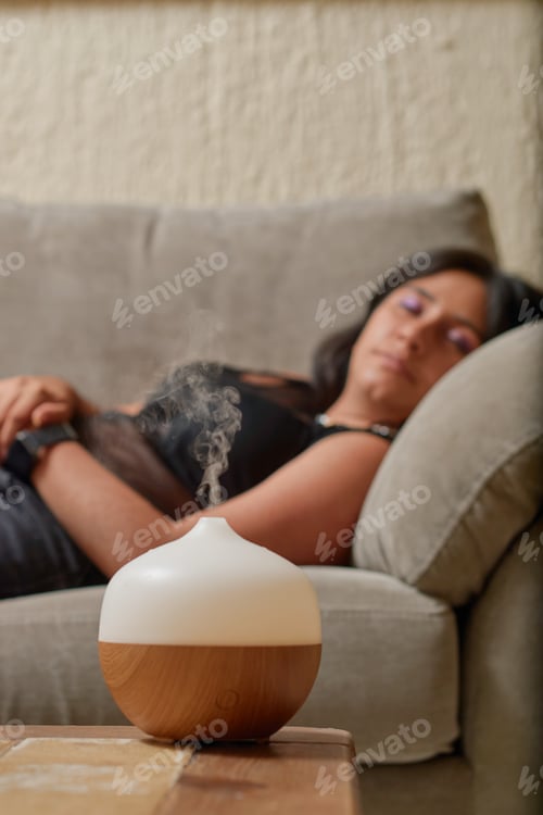 Preview: Young latina woman using aromatherapy to relax. Wellness concept.