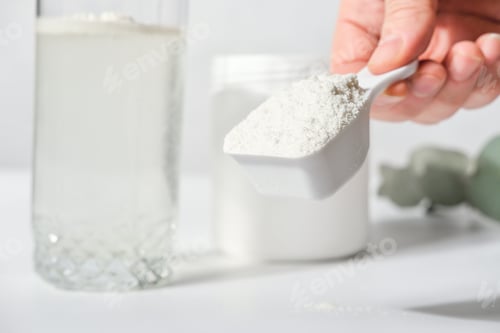 Preview: hand holding scoop of fish collagen. collagen peptides in container or jar.