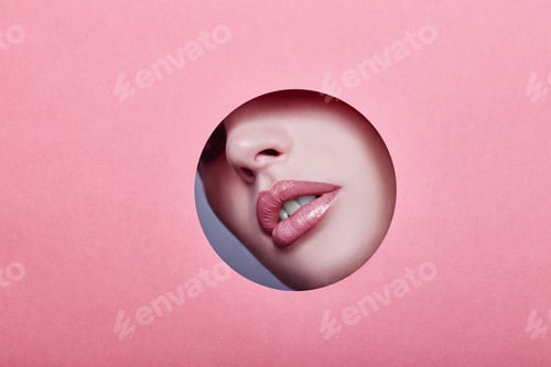 Preview: Woman looking in the hole, bright beautiful makeup, big eyes and lips, bright lipstick