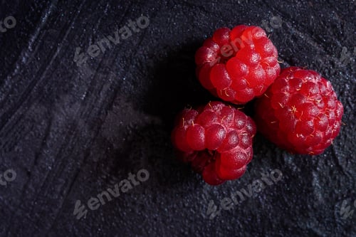 Preview: Raspberry three berries on a black background