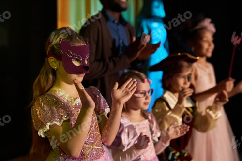 Preview: Teen Girl Wearing Mask and Costume Standing on Stage in Theater Applauding