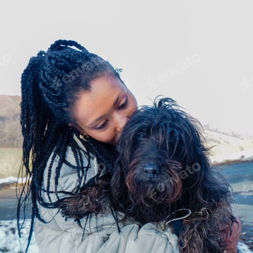 Preview: black young pretty Woman Playing With terrier Dog loving pet in Snow - Enjoying Winter Day Outdoors