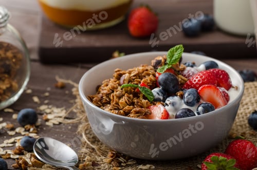 Preview: Yogurt with baked granola and berries in small bowl