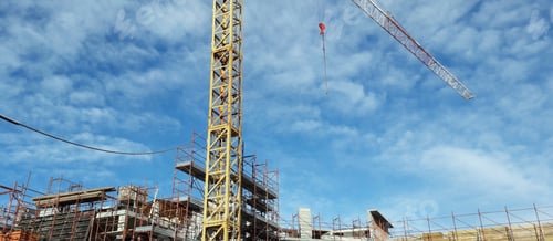 Preview: Tall crane at a construction site under a wispy sky