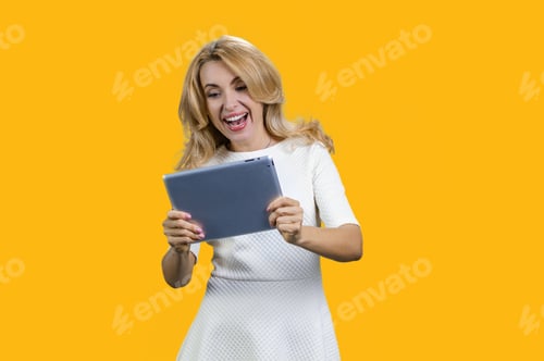 Preview: Portrait of happy mature lady plays video game on the tablet device.