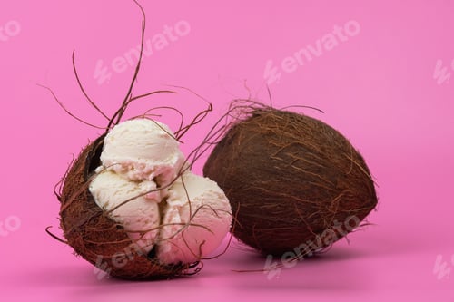 Preview: Vanilla ice cream balls in an empty coconut decorated with mint leaves on a pink background