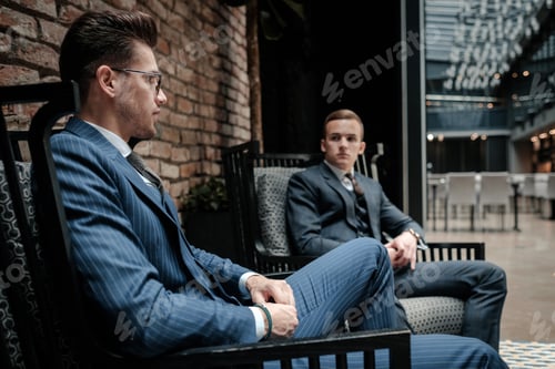 Preview: Men in Suits Sitting in Modern Building