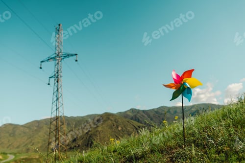 Preview: Power line and pinwheel against the background of green mountains and sky