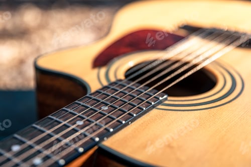 Preview: Close-up, classical acoustic guitar, soft focus in daylight.