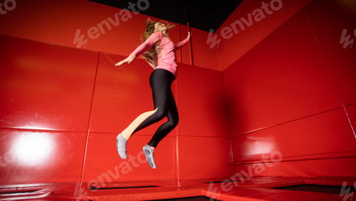 Preview: Houng fit happy woman jumping on trampoline in fintess center